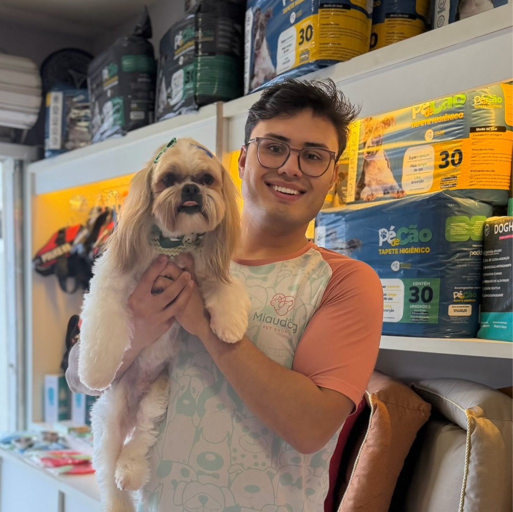 Victor Hugo Monteiro com pet no colo na Miaudog PetStore em Curitiba — carinho e cuidado no banho e tosa